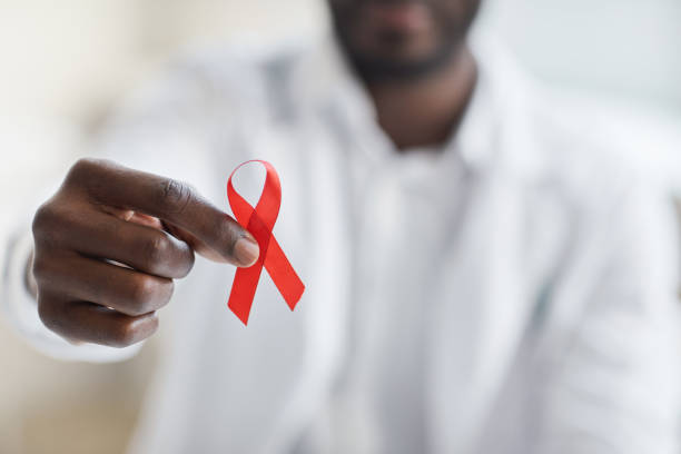 Man holding a red ribbon Close-up of male doctor holding red ribbon hiv stock pictures, royalty-free photos & images