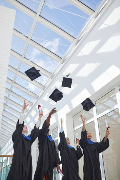 istock Group of graduates throwing caps in sunlight 1319965319