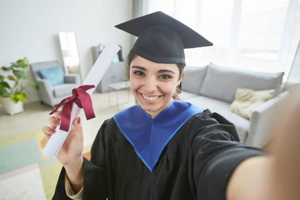 istock Smiling female graduate taking selfie 1319965331