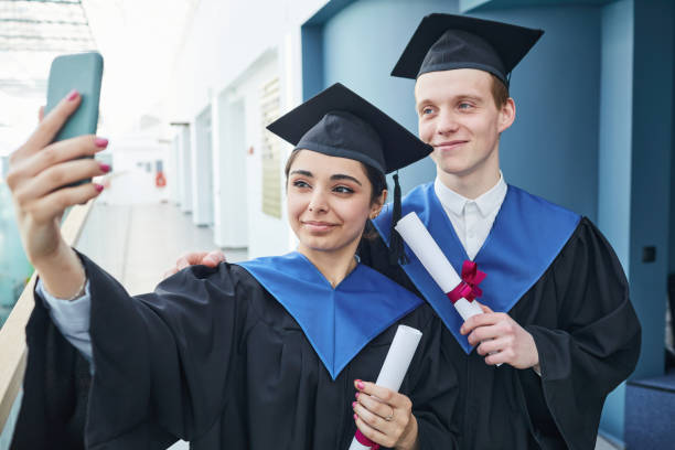 istock Students taking selfie at graduation ceremony 1319965345