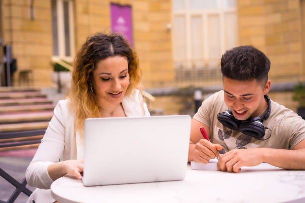 istock Young entrepreneurs doing teamwork. Working on the internet with the computer on a terrace of a bar 1319967437