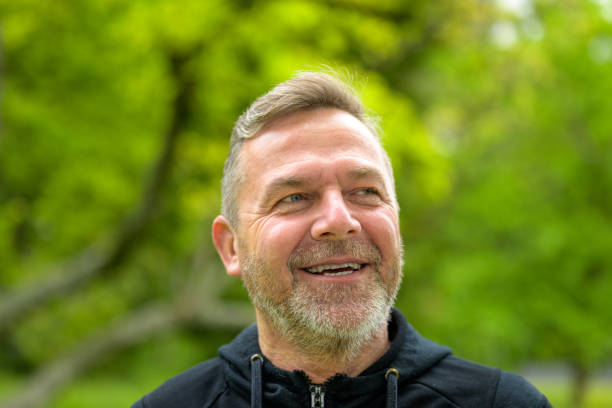 istock Head shot of a smiling middle-aged man outdoors in a park 1319967462