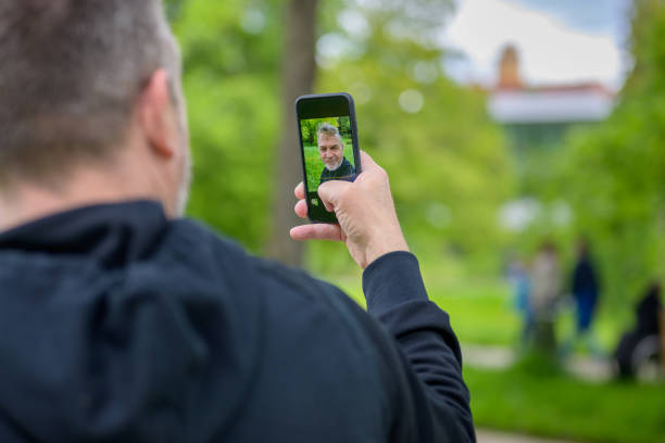 istock Man checking a selfie image on the screen of his mobile 1319967554