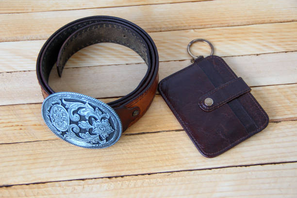 Leather cowboy belt and leather wallet on wooden background Leather cowboy belt and leather wallet on a wooden background wallet gun stock pictures, royalty-free photos & images