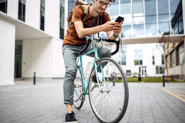 istock Young businessman on a bicycle using a mobile phone 1319969734