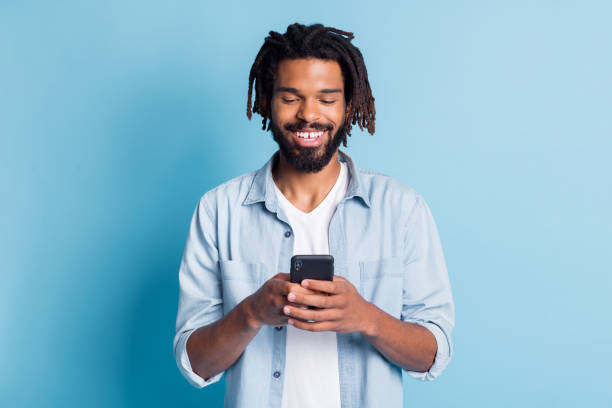 istock Portrait of attractive cheerful focused guy using device chatting free time isolated over bright blue color background 1319970187