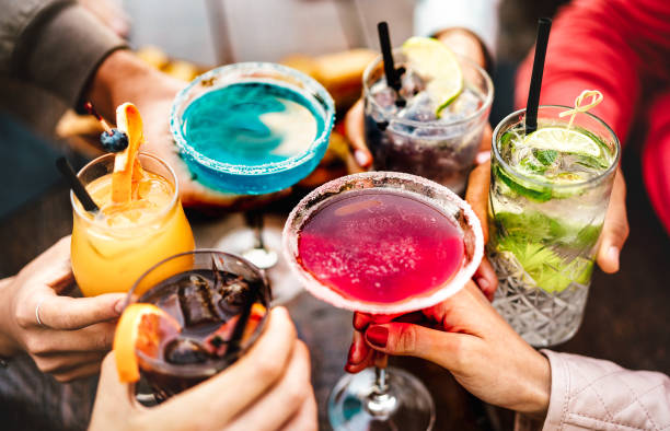 i̇nsanlar çok renkli süslü içeceklere kadeh kaldırıyor - genç arkadaşlar birlikte mutlu saatlerde kokteyl içerek eğleniyorlar - sıcak canlı filtrede sosyal toplantı partisi zaman konsepti - kokteyl stok fotoğraflar ve resimler