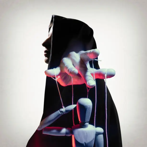 Multi exposure image. Silhouette of woman in cloak and marionette on the string. Concept of control.