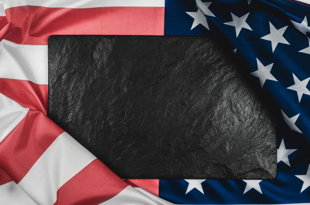 istock Black stone plaque on the American flag with place for text. 1319974635
