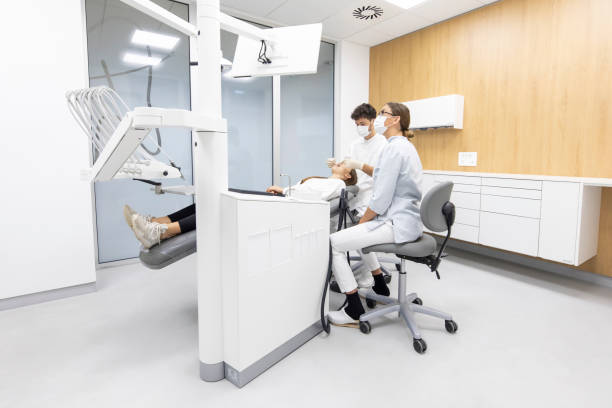 istock Dental hygienist and assistant clean patient's teeth 1319974843