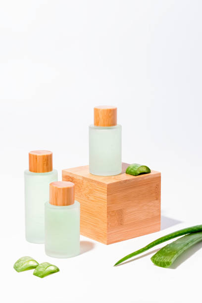 naturkosmetik mit aloe auf holzpodesten in mehrwegflaschen - scincare stock-fotos und bilder