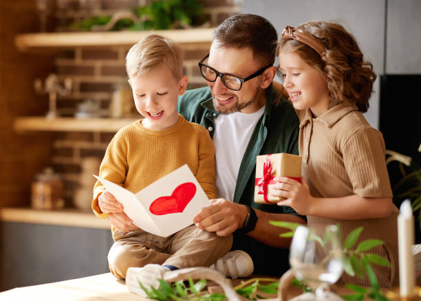 istock Cute children congratulating happy daddy with Fathers day and gi 1319976549