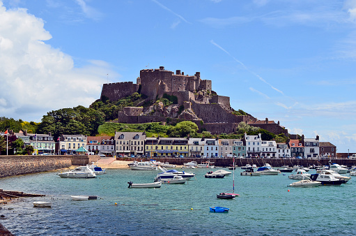 Jersey, UK - June 09, 2011: Mont Orgueil Castle aka Gorey Castle with yacht harbor and building in the tiny town od Gorey