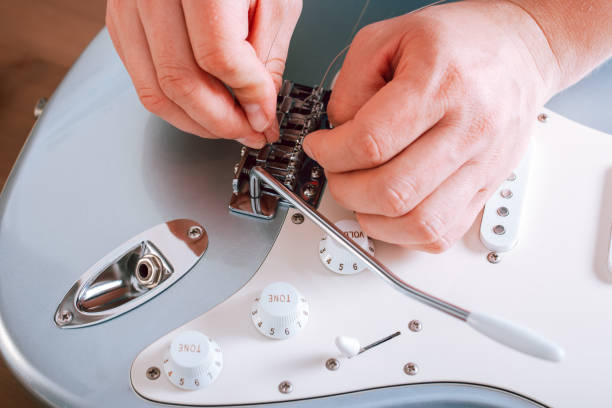 istock Guitar master restringing electric guitar, top view, closeup 1319976796