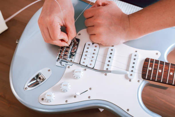 istock Guitar master restringing electric guitar, top view, closeup 1319976840