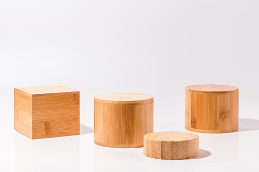 Wooden cube and round podiums for product resentation and display on white table