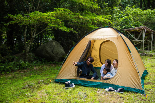 A young family sitting in a tent in a forest stock photo