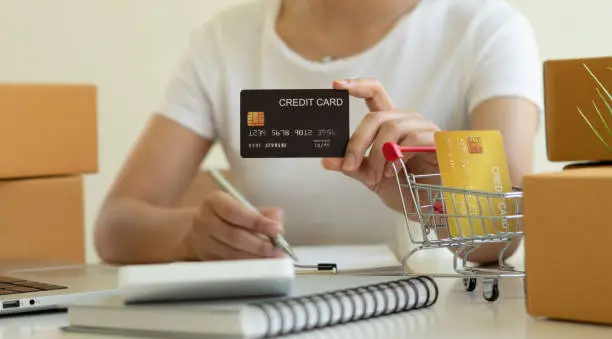 Close up Business woman Hands holding credit card for Online shopping,Online shopping,SME, e-commerce, internet banking, spending money,working from home concept.