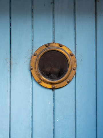 Old gold window on a blue wooden door