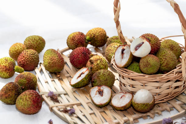 istock Fresh green lychee fruit in bamboo basket on white background. 1319984709