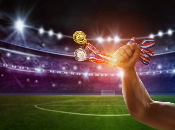 diverse medaglie in mano con lo stadio di calcio sullo sfondo - victory concept - medal soccer success winning foto e immagini stock