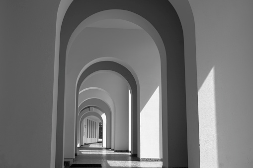 Luxurious lobby with steps, surrounded by row of marble pillars.