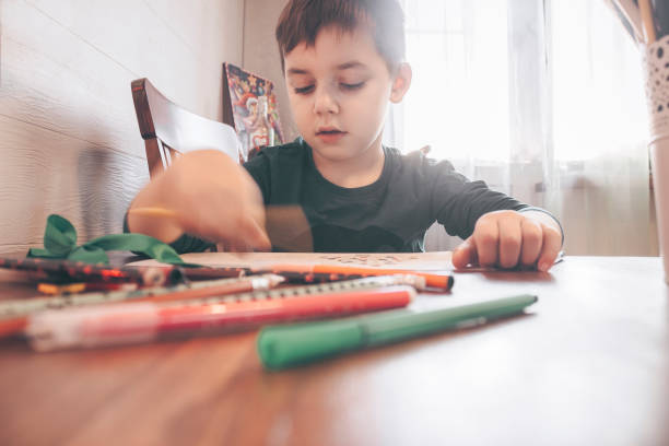 istock cute boy draws with colored pencils 1319985207