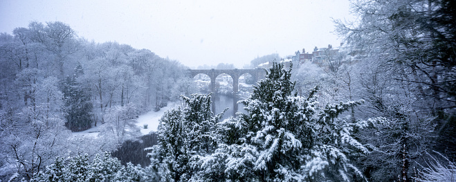snowy winter panorama of the landmark railway viaduct crossing the river Nidd in Knaresborough, North Yorkshire