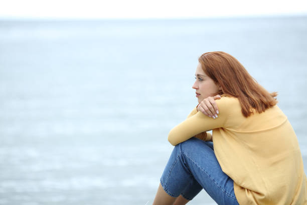 istock Woman contemplating on the beach 1319989754