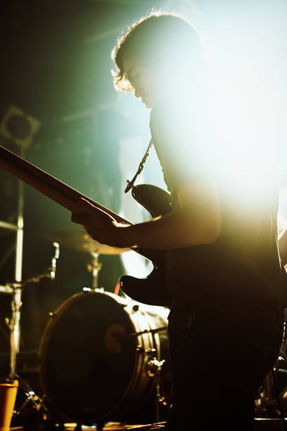 молодой человек страстно играет на бас-гитаре на сцене рок-шоу - concert band стоковые фото и изображения