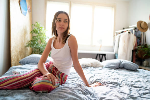 istock Young woman sitting in her bedroom 1319991151