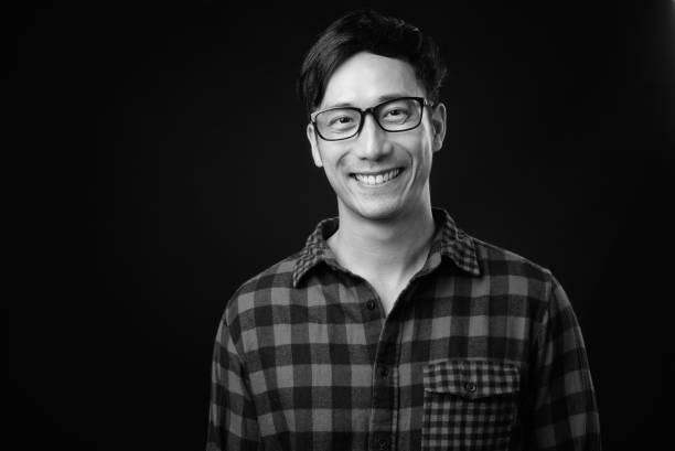 istock Young handsome Asian man against black background 1319991795