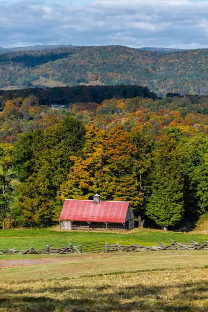 Autumn red colorful trees forest small shed building barn farm on hill high angle view landscape in Monterey and Blue Grass, Highland County, Virginia