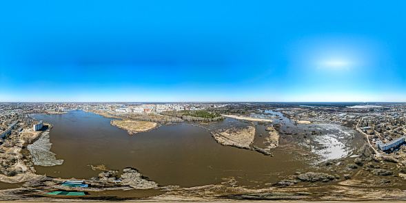 A picturesque cityscape of the Yoshkar-Ola, the Volga region, Russia. The city center, the river embankment and the residential districts during high water. A aerial view of a flood in a town, springtime, sunny day
