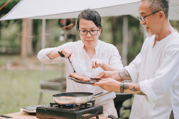 istock asian chinese senior couple cooking at camping preparing dinner 1319994456