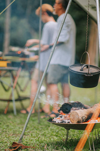 Evening campfire during a camping trip Cauldron on a burning fire wood background family busy preparing dinner
