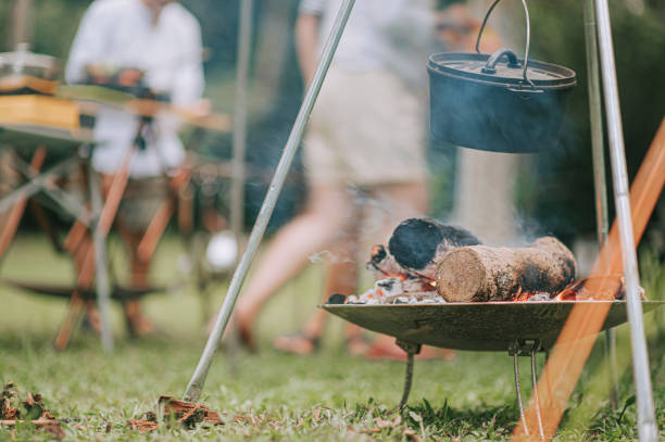 Evening campfire during a camping trip Cauldron on a burning fire wood background family busy preparing dinner