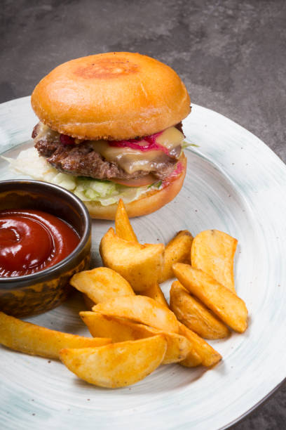 istock Classic burger served with baked potatoes on a plate 1319995977