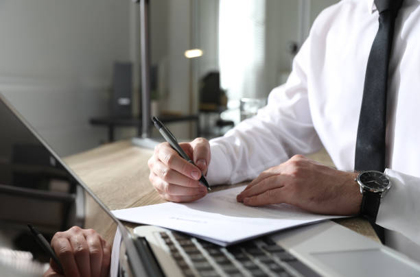 istock Businessman working with documents at wooden desk in office, closeup 1319996382