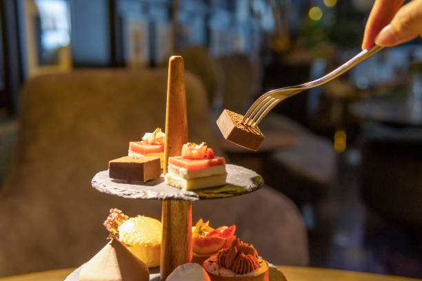 istock Hand using a fork to pick up English afternoon tea desserts 1319997580