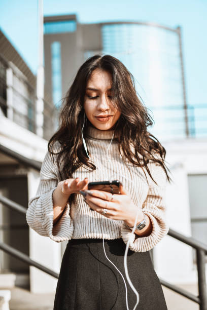 istock Female Using Phone Outside And Listening To Music 1320001193