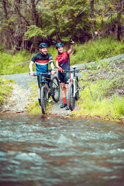 istock Cyclist Couple Looking At Beautiful View Across River 1320002543