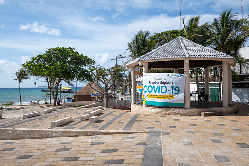 Playa del Carmen, Mexico - May 23, 2021: Early on a quiet Sunday morning near the ferry that departs for Cozumel (background), a pavilion serves as a Covid-19 rapid testing center.