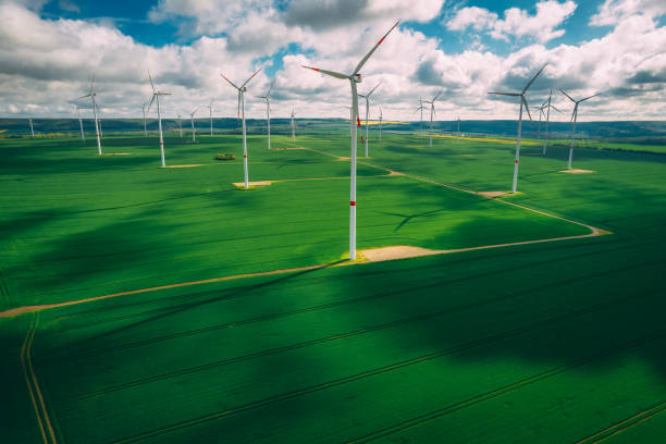 istock wind turbines and agriculture field against clouds 1320005461
