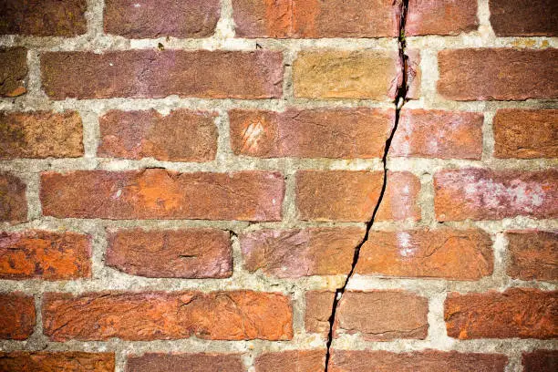 Photo of Deep crack in old brick wall - concept image with copy space