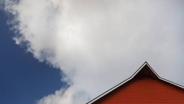 Historic Redwood red barn in front of a cloudy blue sky - dramatic with copy space, no people, rural image stock photo