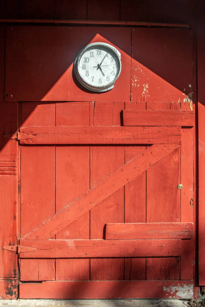 Red barn door wood background with clock, copy space, letter z, no people. stock photo