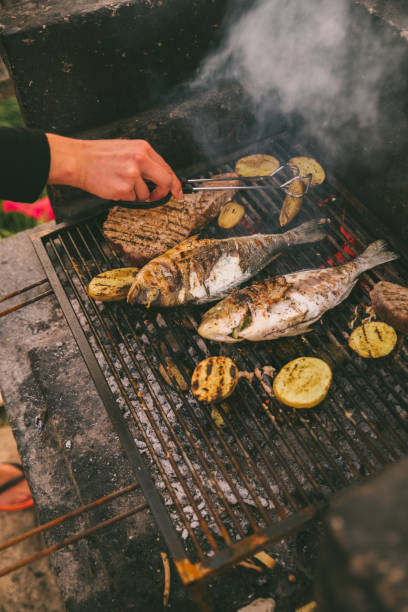 istock cooking fish and potatoes on grill 1320008220