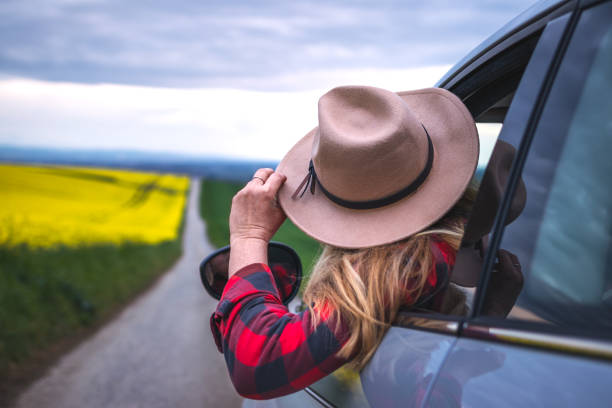 Never knows what is behind the horizon. Road trip vacation Woman driver with hat looking from car window outside. Travel and transportation concept never stock pictures, royalty-free photos & images