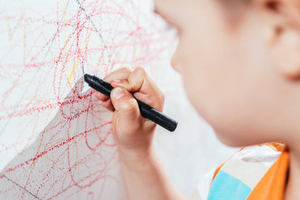 istock Cute child draws on the wall with colored crayons 1320010094